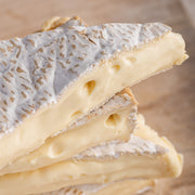 Close up of the oozing cut side of pieces of Brie soft cheese.